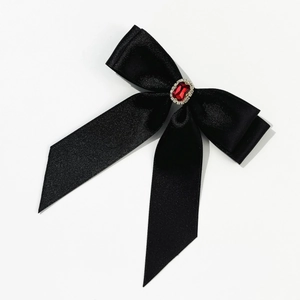 Détail de la barrette à cheveux nœud en satin noir avec cristal rouge rubis central