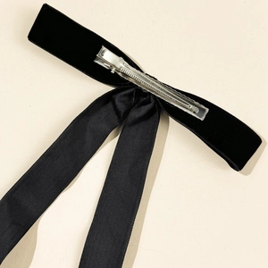 Detail view of the sturdy metal clip on a black velvet bow hairpin with long ribbon