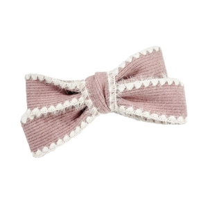 Pink knitted bow hair clip with white fuzzy trim on a clean white background