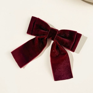 Detail of burgundy velvet bow hair clip with elegant double layers and long hanging ribbons