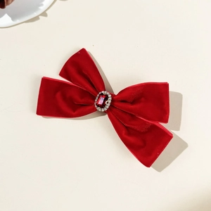Close-up of red velvet bow hair clip with central ruby and rhinestone accents