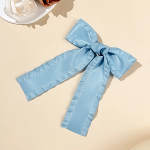 Vue détaillée de la pince à cheveux nœud en satin bleu clair avec texture soyeuse