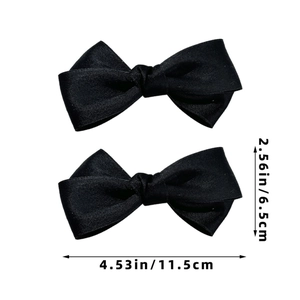 Detail showing dimensions of two black satin bow hair clips measuring 4.53 by 2.56 inches