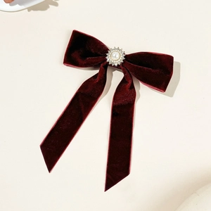 Dettaglio del fermaglio per capelli in velluto bordeaux con perla girasole e strass eleganti