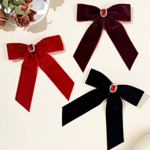 Close-up of velvet bow hair clips with red rhinestones in red, burgundy, and black