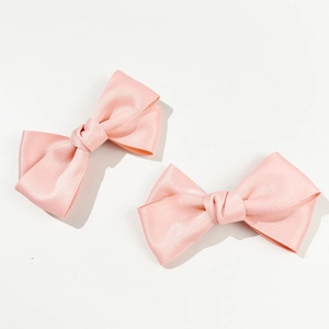 Detailed view of two pink satin bow hair clips with soft silk texture and elegant design