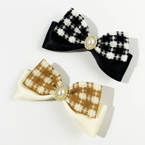 Elegant bow hair clips featuring houndstooth pattern and pearl accents on white background