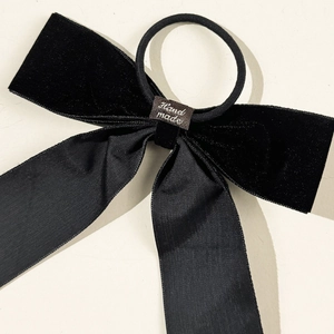 Elegant black velvet and satin bow hair scrunchie with handmade craft label detail