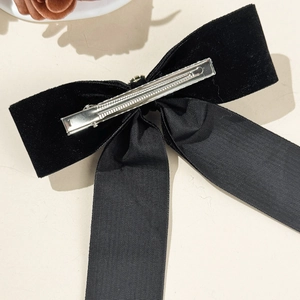 Elegant black velvet bow hair clip with long ribbon streamers and metal spring fastener