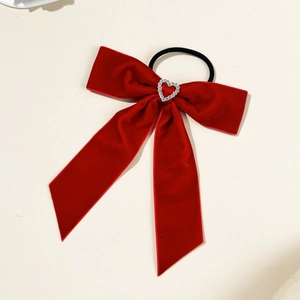 Close-up of red velvet bow hair tie with hollow rhinestone heart centerpiece