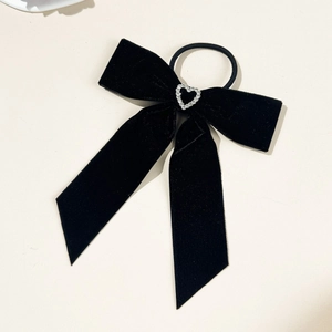 Detail of black velvet bow hair tie with rhinestone heart and long ribbon streamers