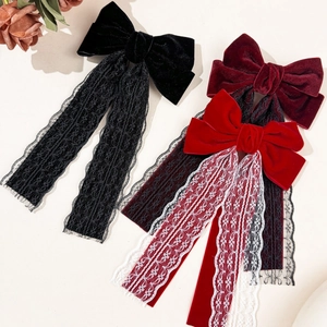 Close-up of velvet bow hair clips with delicate lace ribbons in black and red tones