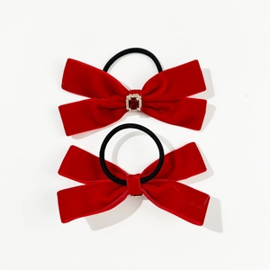 Detail of red velvet bow hair ties with ruby gemstone embellishment in a two-piece set