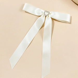 Dettaglio del fiocco in raso crema con strass a cuore e lunghi nastri eleganti