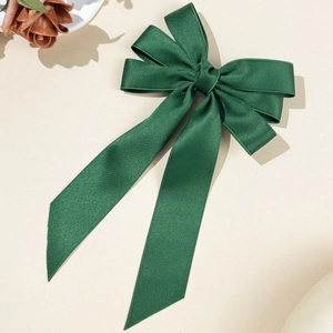 Detail view of dark green layered ribbon hair clip with elegant long streamers