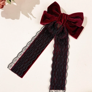 Close-up of velvet bow hair clip with black lace ribbons and delicate texture
