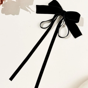 Detailed view of the elegant black velvet bow hairclip with long flowing ribbons