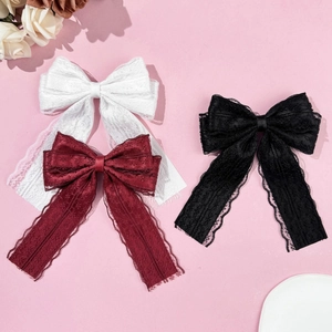 Detailed macro view of lace bow hair clips in white, burgundy and black with long ribbons