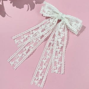 Elegante fermaglio per capelli in pizzo bianco con lunghi nastri su sfondo rosa chiaro