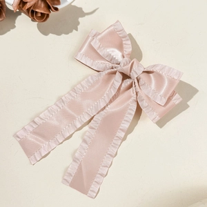 Détail macro du nœud en satin abricot avec bords volantés et longs rubans élégants