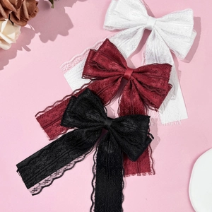 Detailed view of layered lace bow hair clips in white, burgundy, and black colors