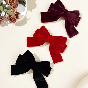 Elegant vintage velvet bow hair clips in wine red, classic red, and black on a white background