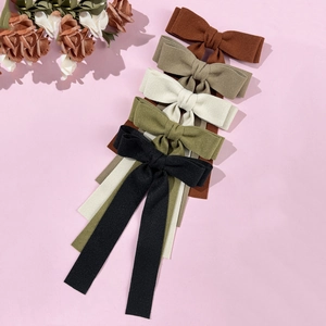 Elegant wool bow hair clips with long ribbons in five colors on pink background