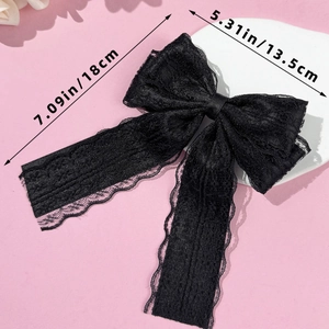 Detail of black lace bow hair clip showing elegant 13.5cm x 18cm double tail ribbon design