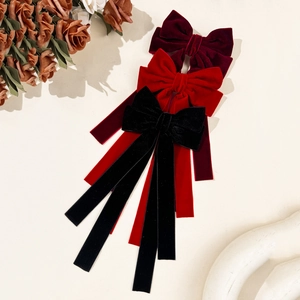 Elegant velvet bow hair clips in red and black with long flowing ribbons for women