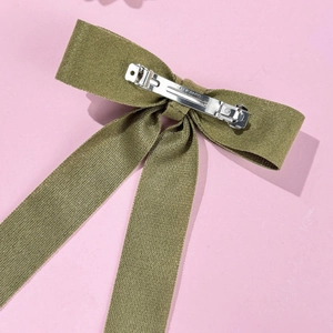 Army green ribbon bow hair clip with a silver metal spring clasp on pink background