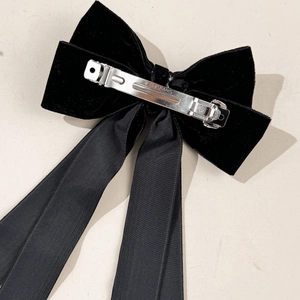 Elegant black velvet bow hair clip with long ribbon streamers and silver metal spring clip
