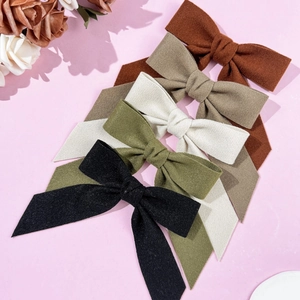 Winter wool bow hair clips set in black, green, cream and brown with soft fabric texture