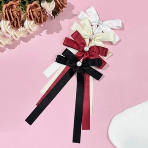 Elegant satin bow hair clip with pearls and long ribbons in white, beige, red, and black