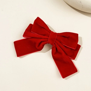 Detailed macro view of large red velvet bow hair clip with premium fabric texture