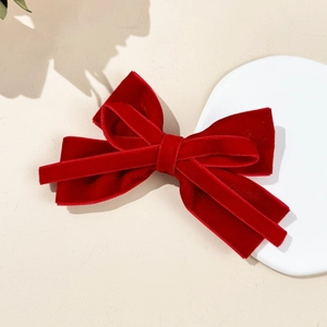 Detailed macro view of the multi-layered deep red velvet bow clip with rich fabric texture