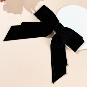 Detail of elegant black velvet double-layer bow hair clip with long silk ribbons