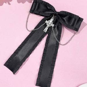 Détail d'une pince à cheveux gothique avec ruban noir, croix argentée et chaînes