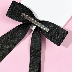 Detail of the black and gold glitter ribbon bow hair clip showing the silver alligator clasp