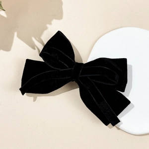 Close-up of elegant black velvet bow hair clip with a multilayered vintage texture