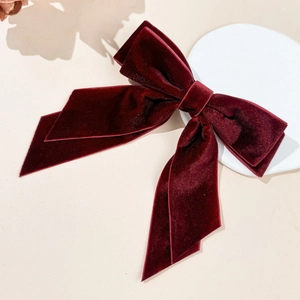 Detail of burgundy velvet double-layered bow hair clip with elegant long ribbons