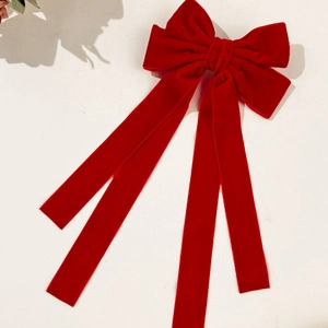 Detailed close-up of premium red velvet bow hair clip with elegant long streamers