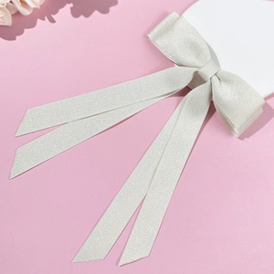 Elegant off-white double-layered ribbon hair clip with long streamers on pink background