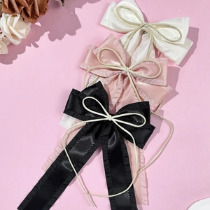 Detailed set of three satin bow hair clips in black pink and beige with ruffled edges