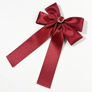 Détail macro du nœud en soie bordeaux élégant avec rubis vintage et centre en diamants