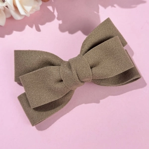 Détail d'une pince à cheveux avec nœud en feutre marron et design double couche rose