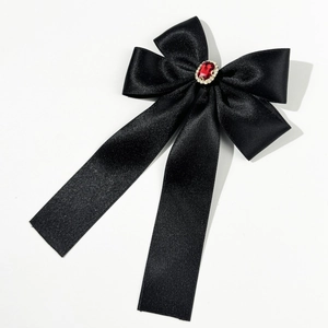 Détail de la pince à cheveux nœud en satin noir avec rubis synthétique et petits strass