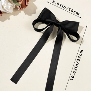 Détail d'un nœud de cheveux en satin noir montrant des dimensions de 15cm par 27cm