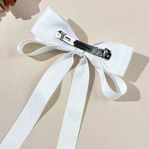 Vue détaillée de l'arrière d'un nœud papillon en satin blanc avec un clip ressort en métal