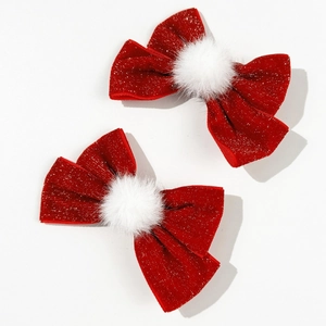 Macro detail of red velvet bow hair clips with silver glitter and white faux fur pompom