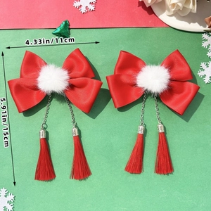 Detail of red bow hair clip with white pompom and long tassels showing dimensions